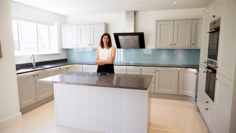 rental property manager standing behind kitchen bench in rental property