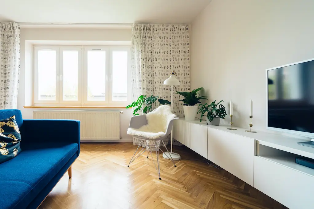 Bright and airy living room with a blue couch and television