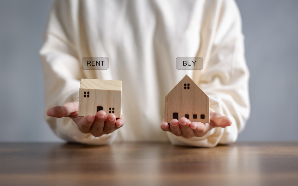 A woman holding up two houses that say rent or buy