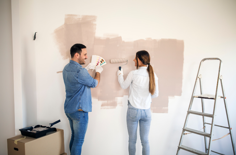 A couple painting their rental property