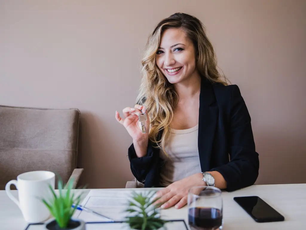 A young woman holding the keys to her first investment property