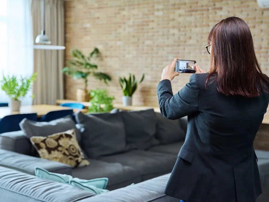 A real estate agent taking professional photos of a real property